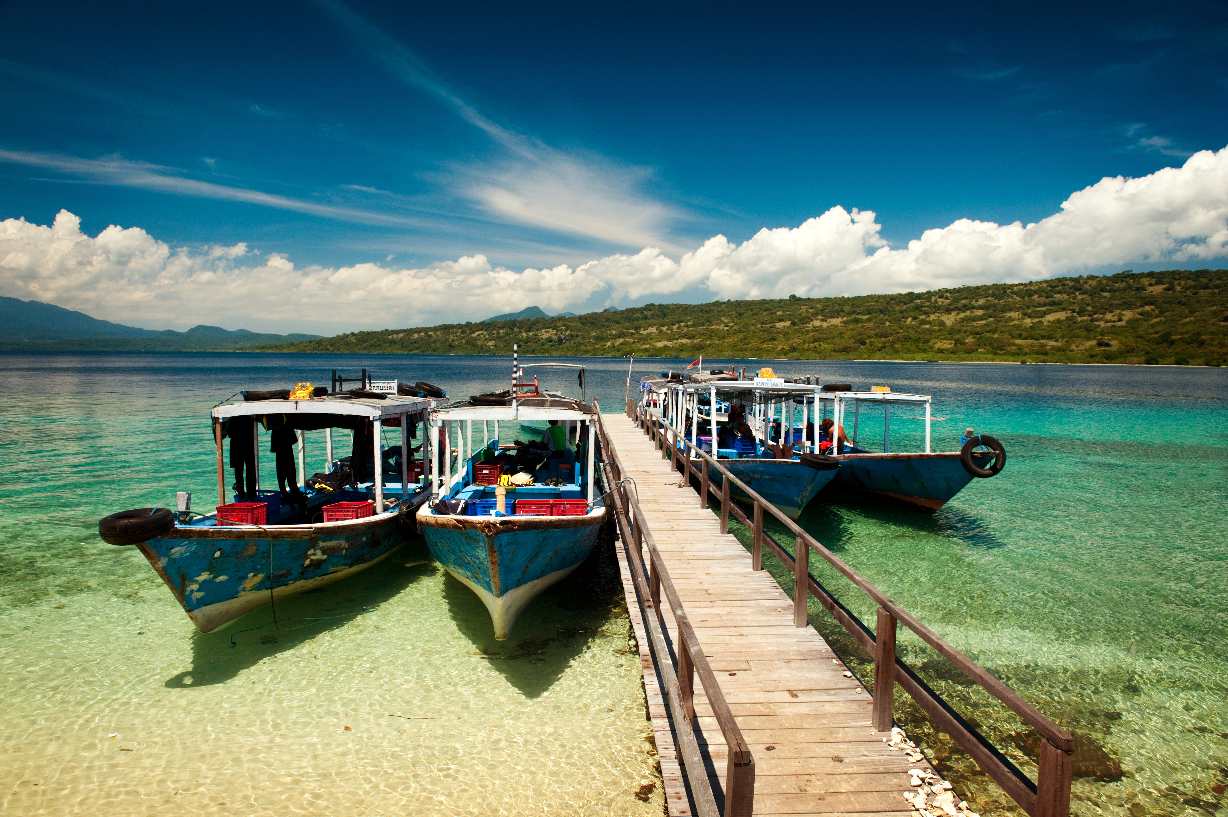 Dive boats wait at the dock on Menjangan Island, Bali, before taking SCUBA tourists out on the magnificent reefs in Bali Barat National Park..jpg