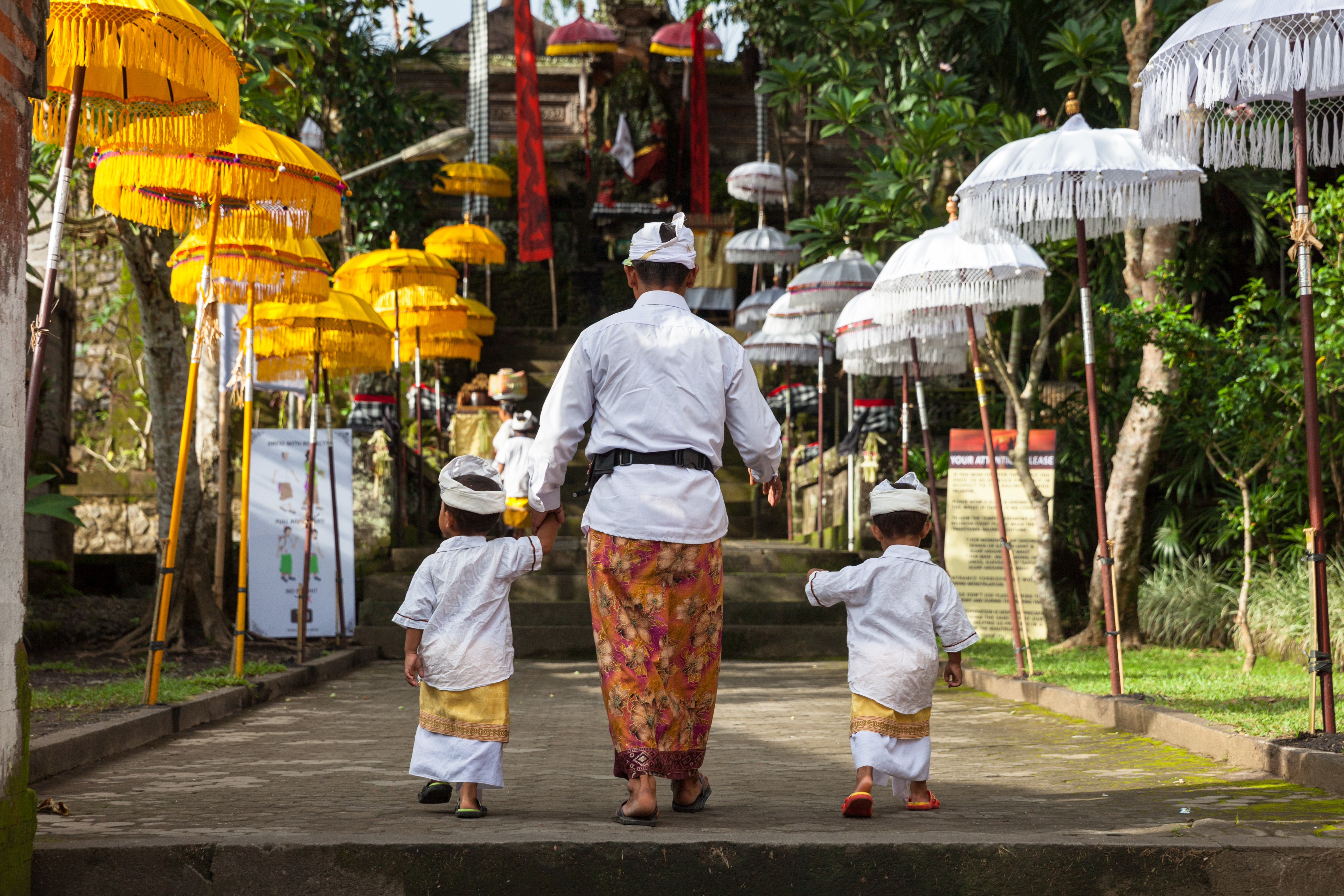 UBUD, INDONESIA - MARCH 2 Man with children walks up the stairs during the celebration before Nyepi (Balinese Day of Silence).jpg