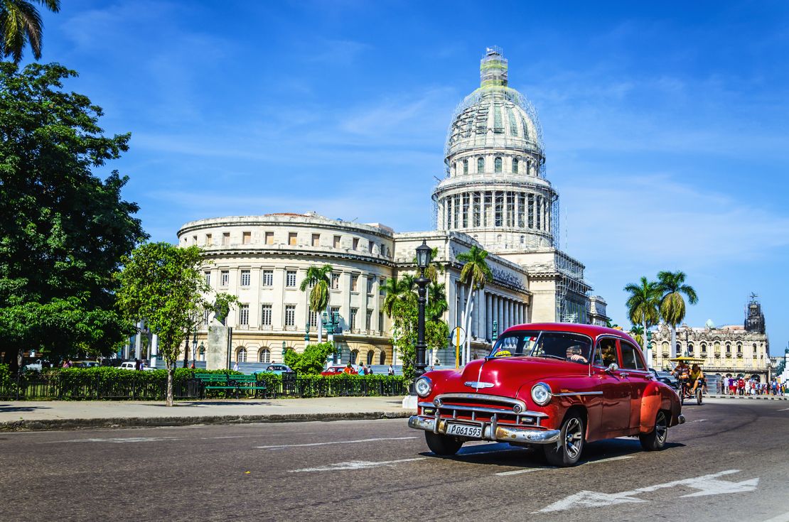 shutterstock_204192301  Old classic American maroon car rides in front of the Capitol.jpg