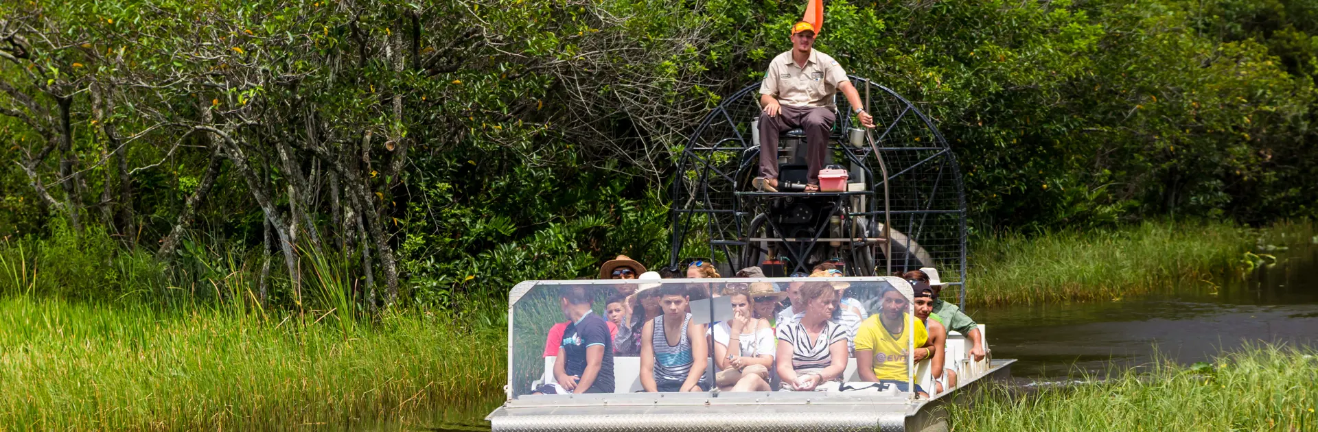 shutterstock_210652315 EVERGLADES, UNITED STATES - August 10, 2014 group of tourists riding an airboat..jpg