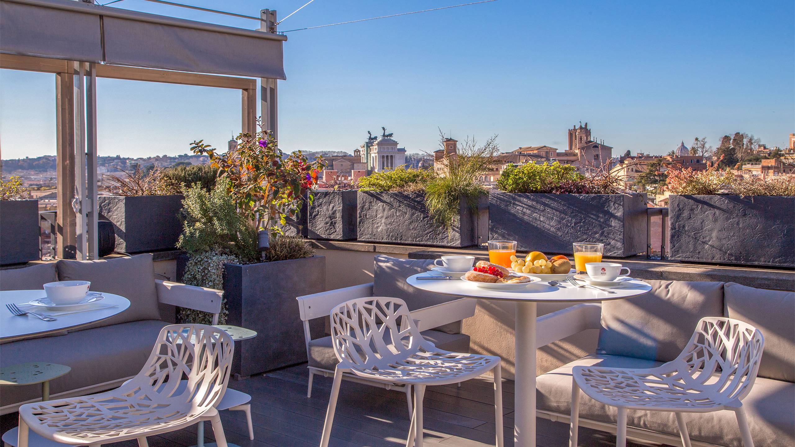 Nyt frokosten på takterrassen med utsikt over hustakene i Roma