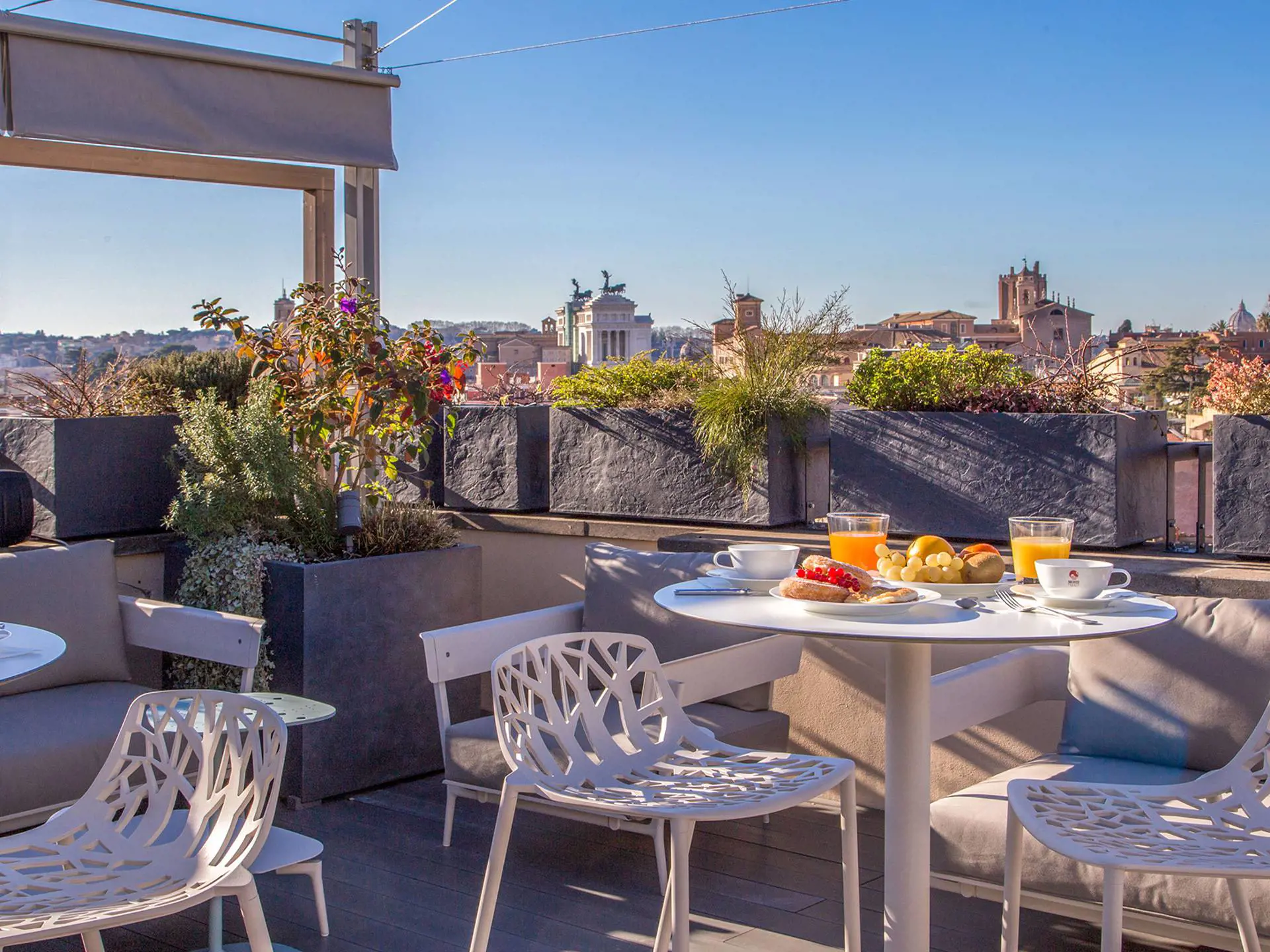 Nyt frokosten på takterrassen med utsikt over hustakene i Roma