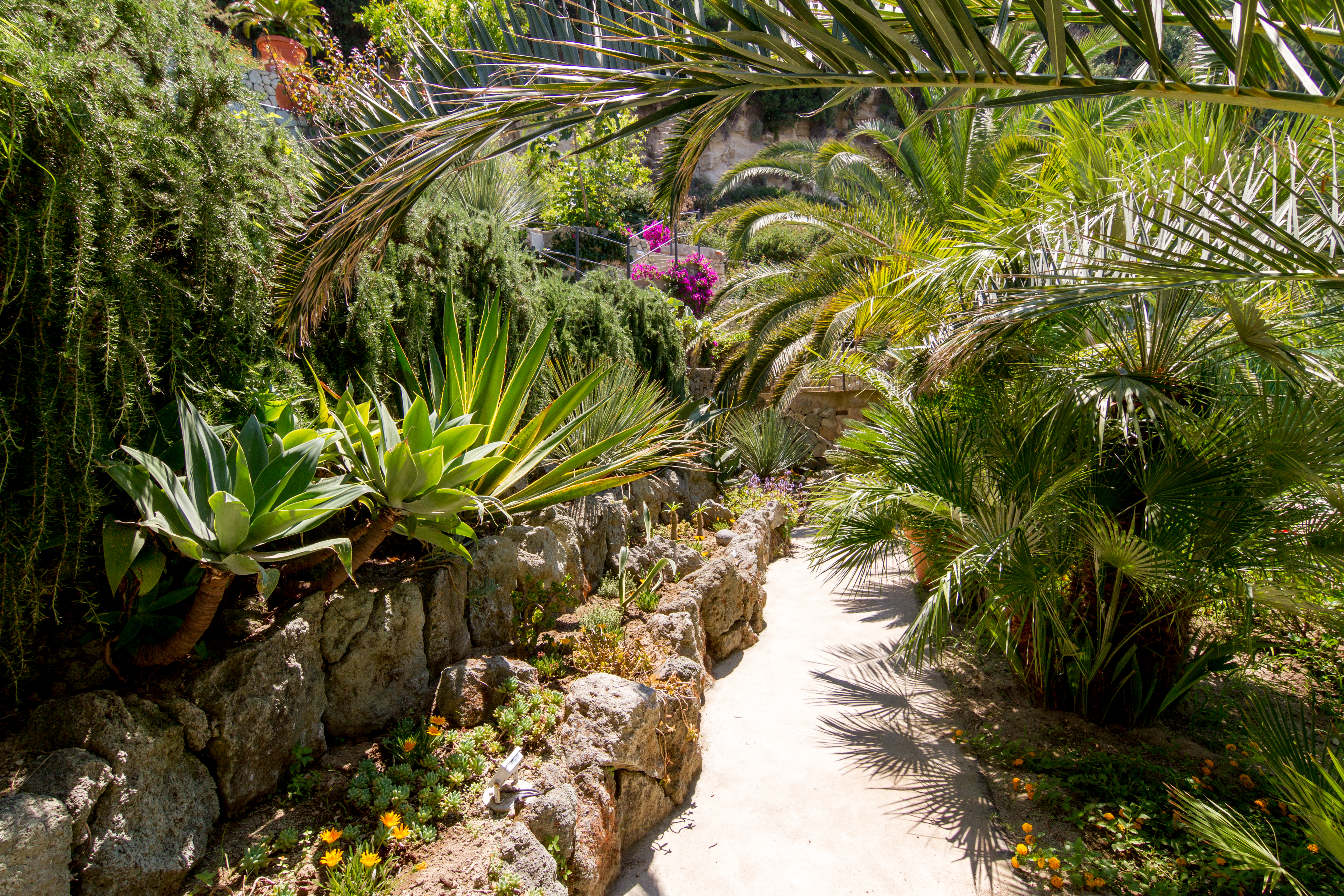 Små stier fører fra en hage og basseng til den neste