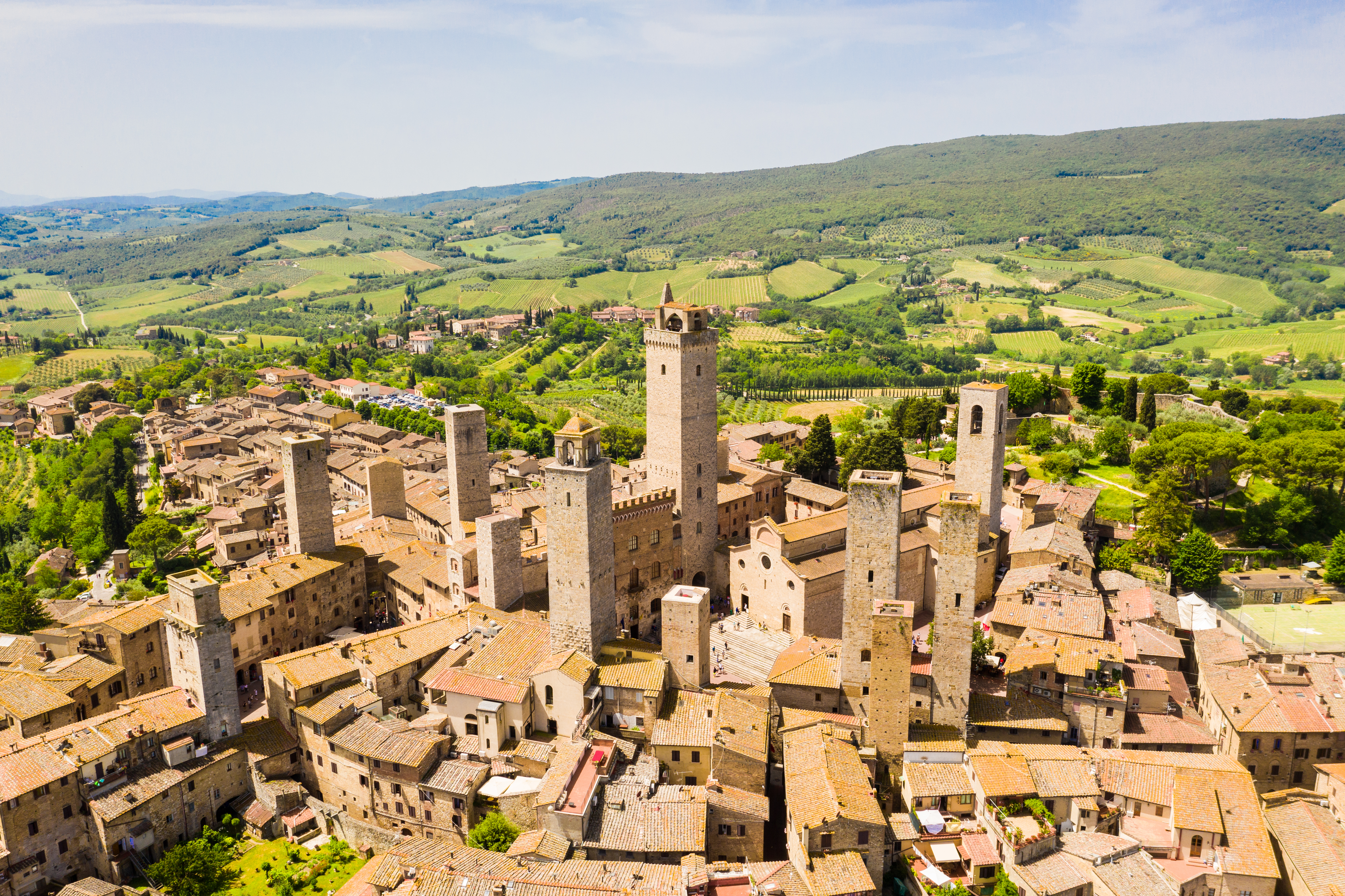 Den gamle middelalderbyen San Gimignano omgitt av det bølgende grønne landskapet i Toscana
