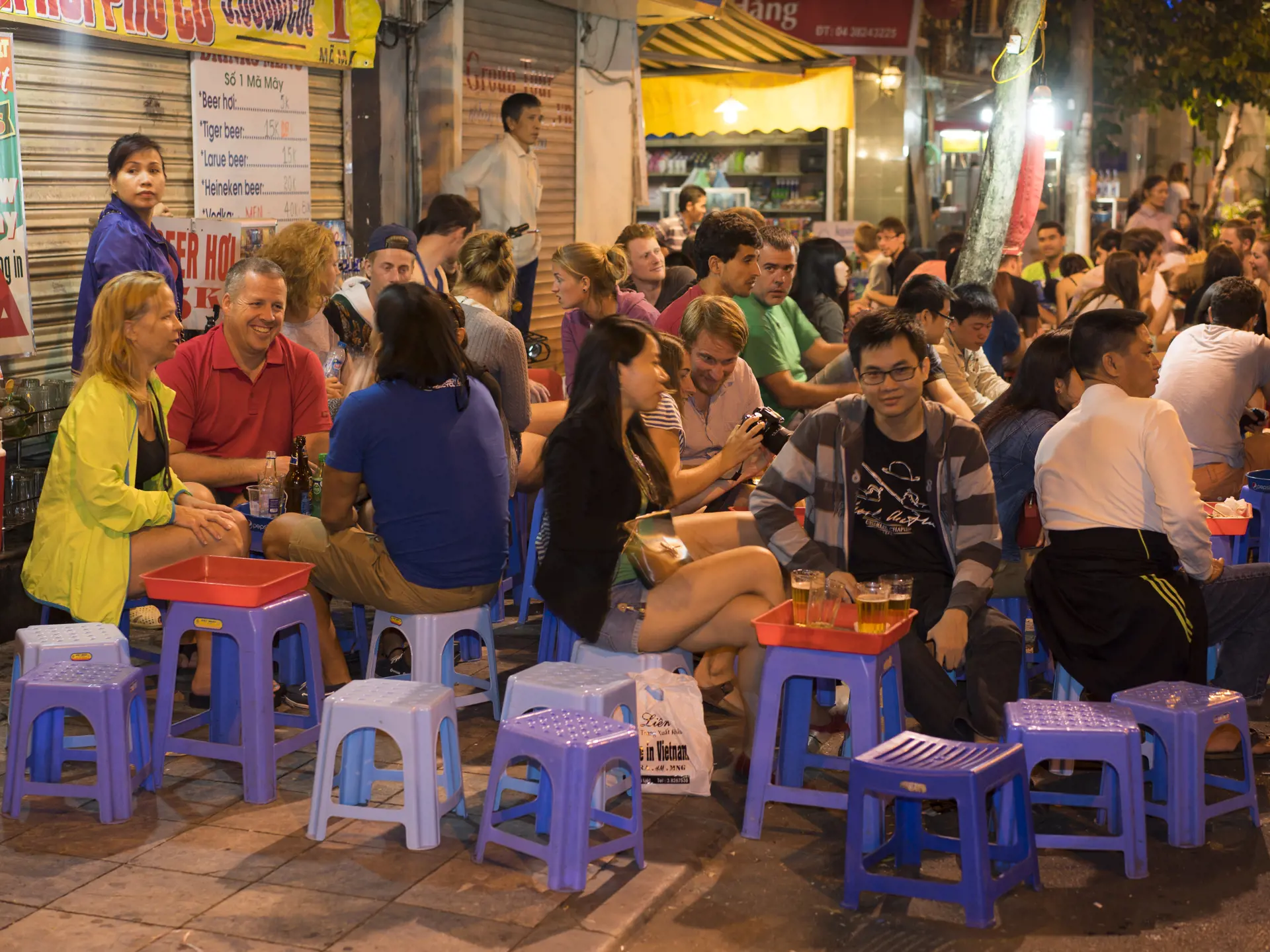 shutterstock_228924229 People drink beer on street at night in old quarter, center of Hanoi..jpg