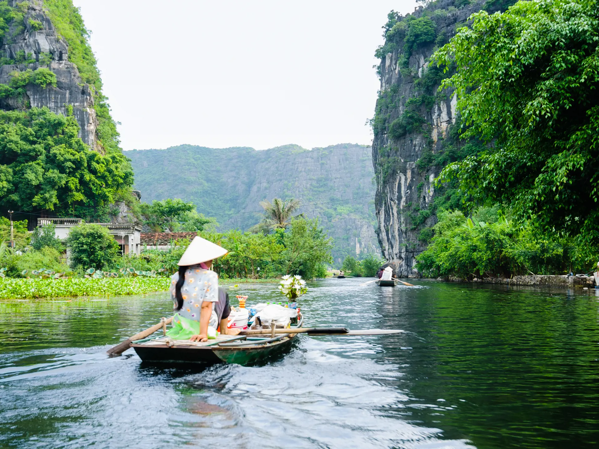 The woman is paddling groceries and fresh flowers boat. Tam Coc Grotto, Ninh Binh Province, Vietnam.jpg
