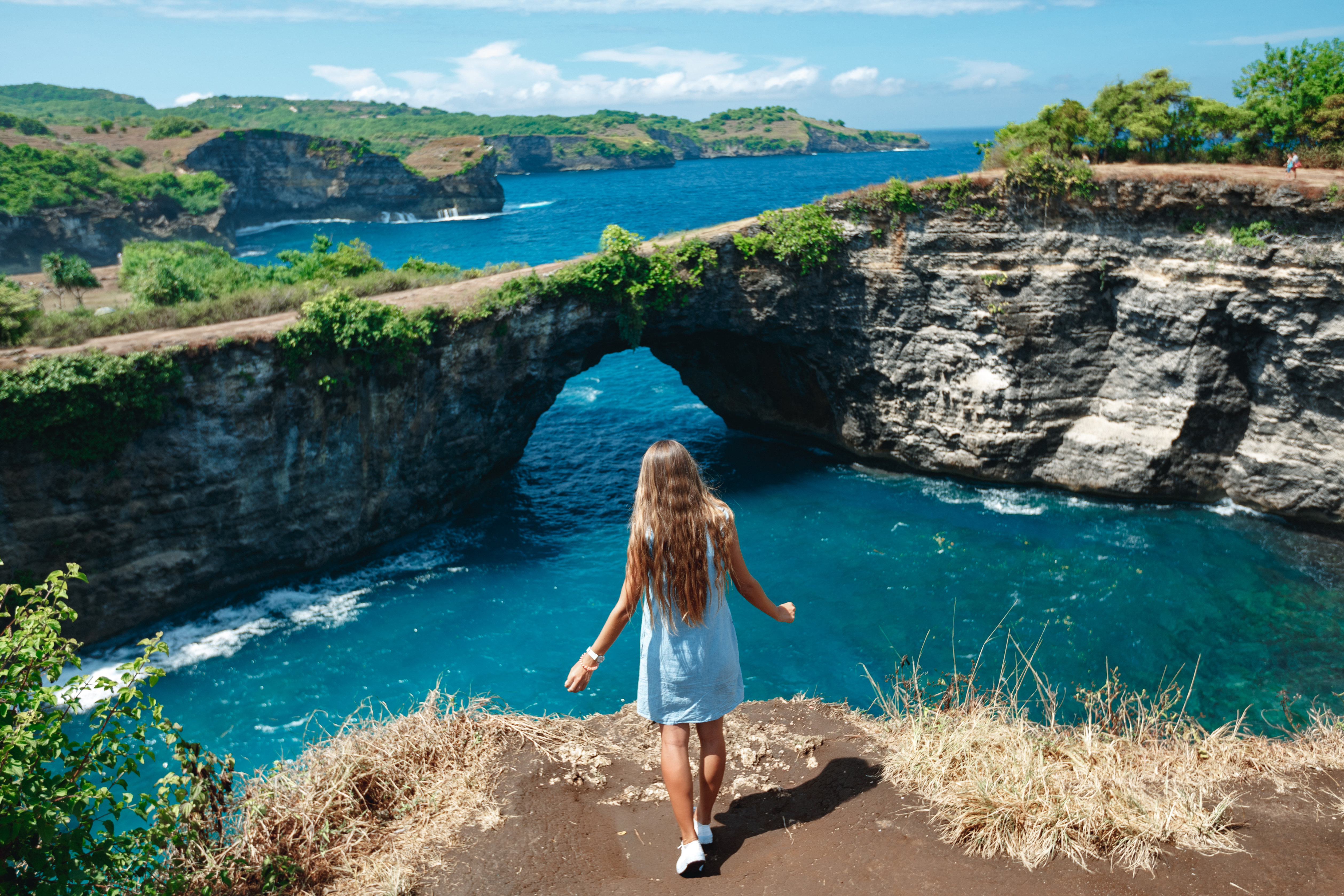 Shutterstock 1485852206 (Back View Woman On The Edge Of A Cliff Looking On Broken Beach. Broken Beach Nusa Penida Popular Travel Destination In Indonesia)